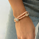 Pulsera rosario elástica en cristal de murano beige talla S con dijes de santos en zamak y cruz de madera.