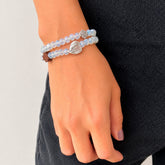 Pulsera rosario elastica doble vuelta en cristal de murano transparente con cruz de madera y medallas de santos en zamak, talla S