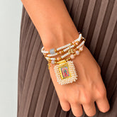 Modelo con Pulsera Escapulario Beige con Dije de Fe y Medalla Padre Nuestro – VII Sacramentos Colombia