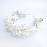 Diadema blanca para Primera Comunión de niña con flores de tela de gasa y un delicado tejido de alambre con perlas de imitación sobre un fondo de lino beige - VII Sacramentos Colombia