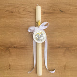 Vela de bautizo con figura dorada de paloma y medalla de cuna italiana repujada en relieve con la imagen de la Sagrada Familia y estrellas.