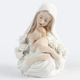 Imagen religiosa de la Madona con el Niño y rosas blancas. Figura devocional de la Virgen María abrazando al Niño Jesús, símbolo de amor maternal y pureza, elaborada en material tipo porcelana blanca con acabado brillante.