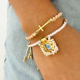 Set x 2 Pulseras – Macramé Beige con Cruz Dorada & Pulsera con Escapulario Rebordado