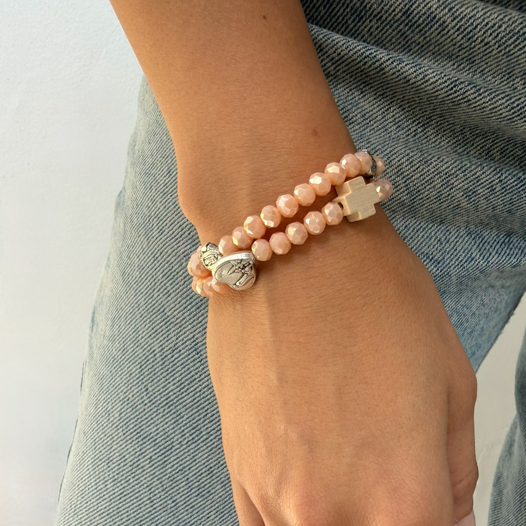 Pulsera rosario elástica en cristal de murano beige talla S con dijes de santos en zamak y cruz de madera.