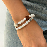 Pulsera rosario elástica doble vuelta en cristal de murano blanco con cruz de madera y medallas de santos en zamak, talla S