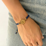 Pulsera Tejida con Medalla en Acero Dorado Mediana Hilo Azul – VII Sacramentos Colombia
