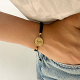 Pulsera Tejida con Medalla en Acero Dorado Mediana Hilo Negro – VII Sacramentos Colombia