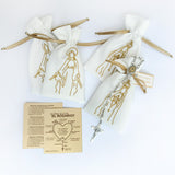 Pack de 6 recordatorios religiosos con rosarios de perla blanca, bolsas de tela bordadas en hilo dorado y guías de oración sobre fondo blanco.