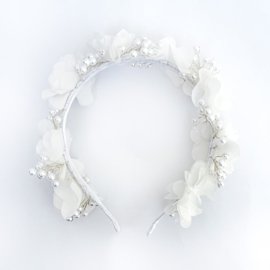 Diadema blanca para Primera Comunión de niña con flores de tela de gasa y un delicado tejido de alambre con perlas de imitación sobre un fondo de lino beige - VII Sacramentos Colombia