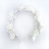 Diadema blanca para Primera Comunión de niña con flores de tela de gasa y un delicado tejido de alambre con perlas de imitación sobre un fondo de lino beige - VII Sacramentos Colombia