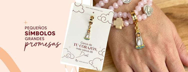 Dije de la Virgen de Fátima esmaltado colgado en una pulsera de cuentas rosadas junto a su empaque con la frase "Cerca de tu corazón, más cerca de Dios".
